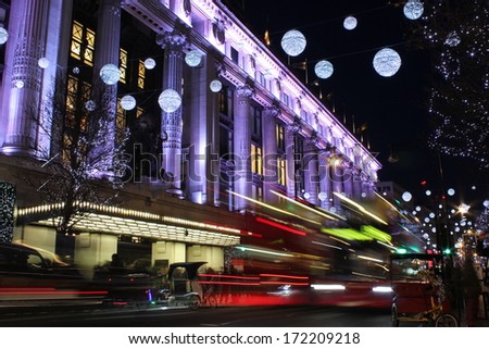 London at night. Long exposure shot of blurred bus speeding through night street.