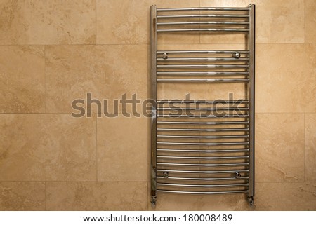 Wall Hung Chrome Curved Towel Radiator on Travertine Tiles