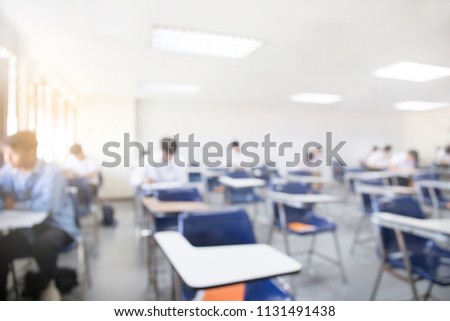 blur focus.front view abstract background of examination room with college students inside. university student in uniform sitting on lecture chair taking final exam or study at classroom in school.
