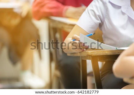 Blur abstract background of examination room with undergraduate students inside. student sitting on row chair doing final exam in classroom.