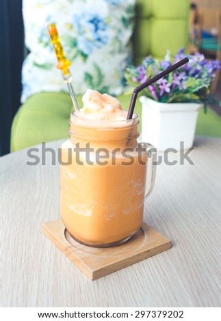 Thai milk tea frappe on wooden table