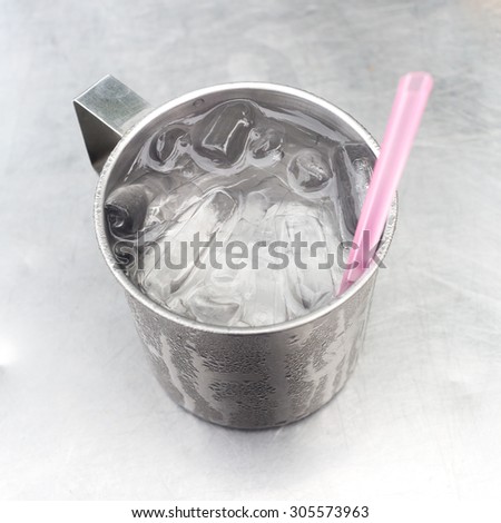 Drink water in metal cup used for drink fresh water at street food stall.