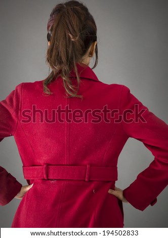 Rear view of an Indian young woman standing with her arms akimbo