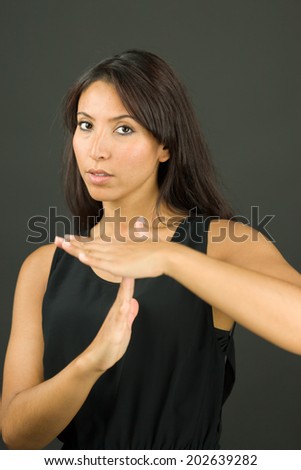 Portrait of a young woman making time out signal with hands