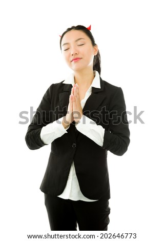 Devil side of a young Asian businesswoman in prayer position isolated on white background