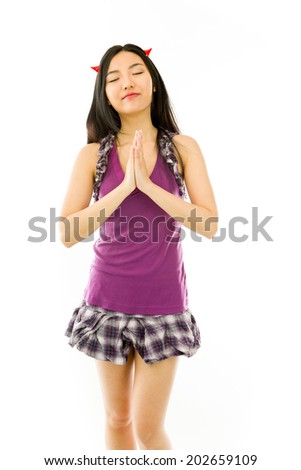 Asian young woman dressed up as a devil in prayer position isolated on white background