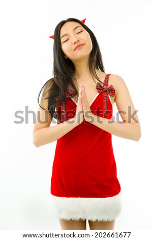 Devil side of a young Asian woman standing in prayer position isolated on white background