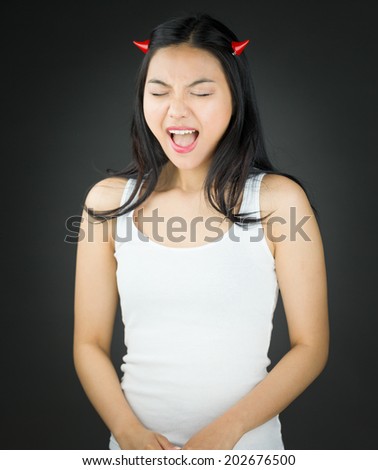 Asian young woman in devil horns shouting in excitement