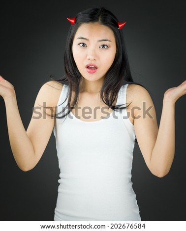 Asian young woman in devil horns don\'t know what to do