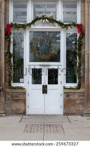 Entrance of front door of a residential home decorated with a Christmas wreath