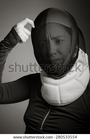 Close up of a female fencer in fencing mask with scratching head