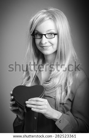 Attractive caucasian blond girl isolated on a grey background, black and white image