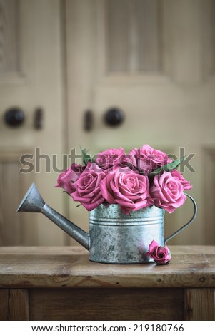 Vintage watering can with roses