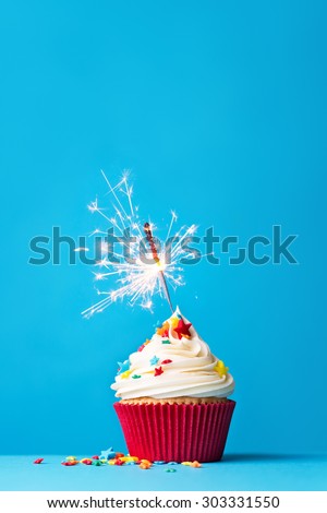 Cupcake with sparkler against a blue background