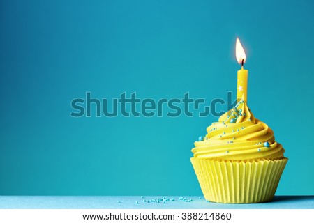 Yellow birthday cupcake on blue