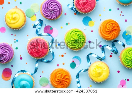 Colorful cupcake party background on blue