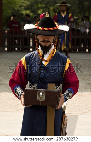 SEOUL, KOREA - MAY 14, 2015:  Armed guards in traditional costume guard the entry gate at Deoksugung Palace, a tourist landmark, in Seoul, South Korea on May 14, 2015
