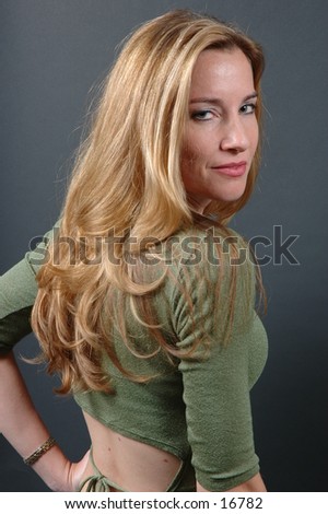 Sexy shot of a pretty model  with golden hair in green shiny top showing small of the back