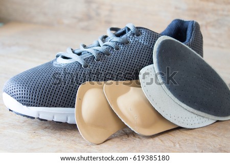 Gray running shoes with orthopedic insoles. Wooden board