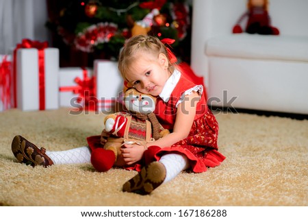 Happy dreaming child holding Christmas decoration under the Christmas tree