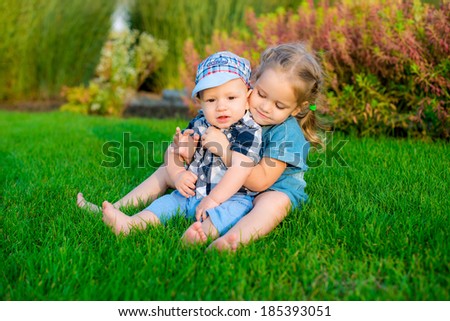 happy sister and brother hugging in the park
