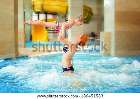 young swimmer girl on swim start at swimming pool coin gymnastic. Mother teach her daughter to swim and to jump. Jacuzzi