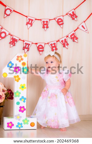 Little girl celebrate first Happy Birthday Party with  decor in the beautiful  bright room