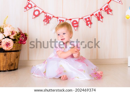 Little girl celebrate first Happy Birthday Party in dress with  decor in the beautiful room