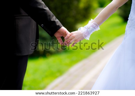 hands of the bride and groom hold each other bride in wedding gloves
