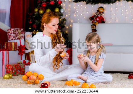 happy family home near the Christmas tree eating citrus