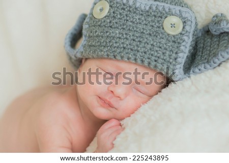 baby sleeps in a knitted hat with ear-flaps