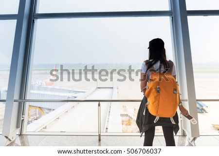 Woman waiting for a flight at the airport; window airport.