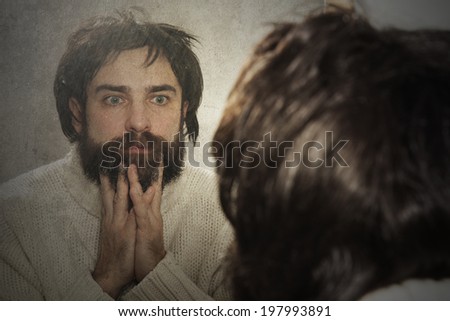 Man unhappy looking in the old mirror