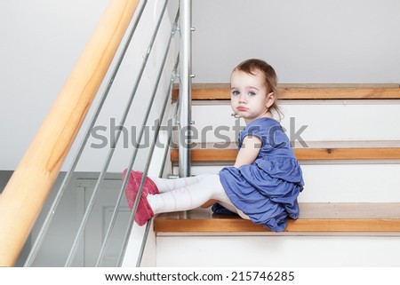 Little girl sad sitting on steps