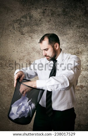 Man searching his document in paper bin