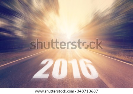 Abstract blurred country road and field and with,sunlight. Forward target to the New Year 2016.