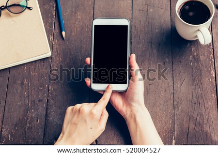 Close up of women hand holding phone with blank copy space screen for your advertising. Hand woman using phone in coffee shop.
