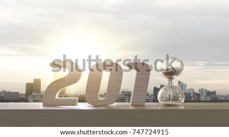 2018 happy new year. Resolutions, goals, start up, refresh concept. Wood numbers and hourglass clock on wooden tabletop on panoramic skyline and buildings in the morning background.