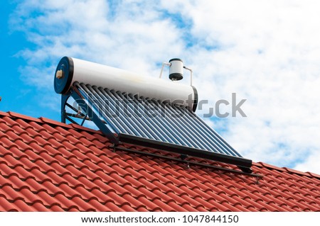 Solar water heater on roof top, beautiful blue sky background.