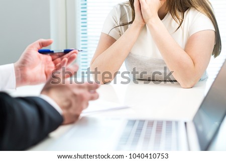 Young woman getting fired from work in office. Boss complaining or giving negative feedback to unhappy worker. Sad job applicant after failed interview. Business man telling bad news to employee.