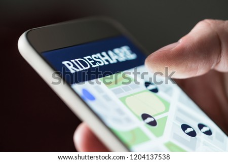 Ride share app in smartphone. Man using rideshare taxi application. Online carpool or carsharing service in mobile phone. Macro close up of cellphone screen.