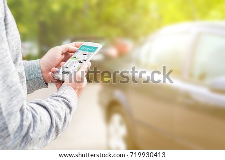 Online ride sharing and carpool mobile application. Rideshare taxi app on smartphone screen. Modern people and commuter transportation service. Man holding phone with a car in background.