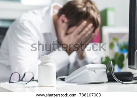 Stressed doctor cover face under pressure. Sad nurse, tired physician or upset doc. Medic crying in hospital office. Malpractice, treatment error and mistake or negligence. Workplace bullying.