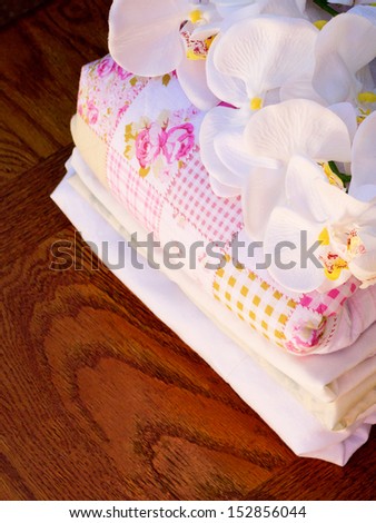 Stack of fresh laundry with a sprig of flowers on top