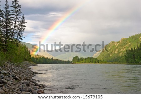 rainbow above river in mountains
