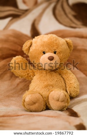 bear toy sinning on the brown carpet