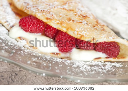 Crepes with crepes with vanilla cream and raspberries