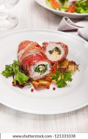 chicken breast wrapped in parma ham stuffed with gorgonzola and herbs served with baked potatoes