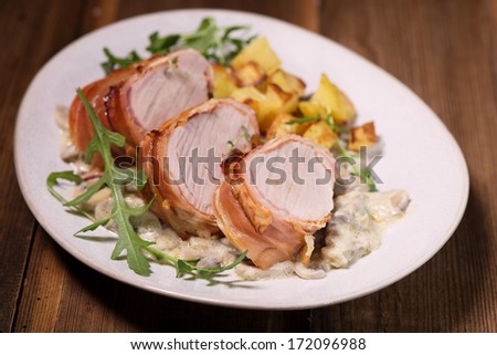 Pork Tenderloin Wrapped in Prosciutto ham with mushrooms sauce and baked potatoes