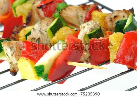 Chicken or turkey kebabs with peppers, zucchini and pineapple on the grill grate